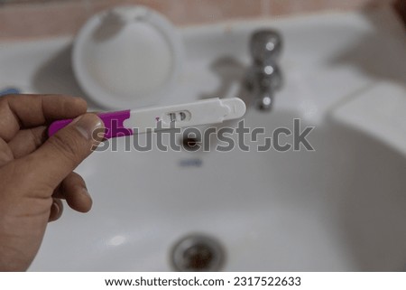 Close up of woman hands holding positive home pregnancy test