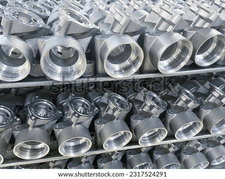 batch of machined die cast aluminum parts placed on a rack, automotive parts mass production, CNC machining, mass production of die casting parts, aluminum die cast parts mass production Royalty-Free Stock Photo #2317524291