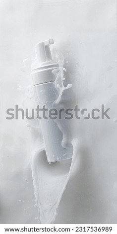 Cosmetic container white lotion droplet fly splashing. Milk lotion pour float to cosmetic bottle. Moisturizer lotion explosion spill. White background isolated high speed shutter freeze top view