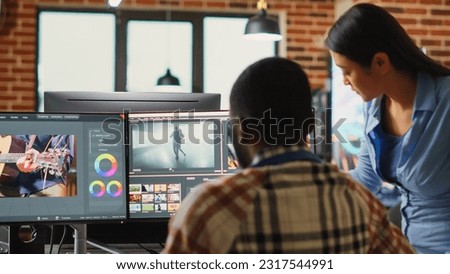 Professional video editors analyzing film montage before editing color grading and lighting, doing teamwork in creative office. Post production house employees working with video footage.