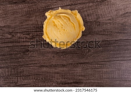 Tasty yellow scoop of ice cream. Frozen desserts from ice cream parlors and gelato parlours. Top image with empty space below.