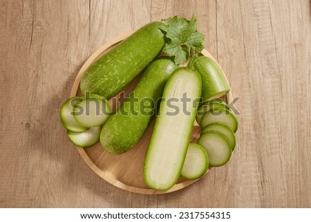 Top view of a wooden tray in round-shaped containing many round slices of winter melon. Winter melon (Benincasa hispida) is rich in vitamin C and antioxidants that improve skin health Royalty-Free Stock Photo #2317554315