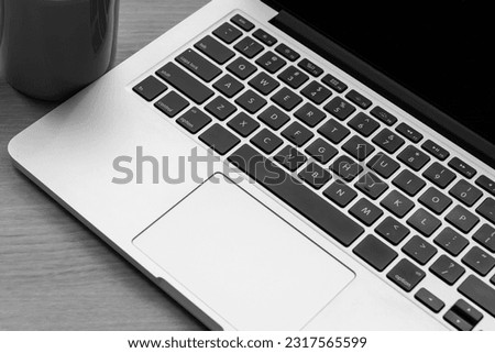 A laptop and a cup are placed on the table. meeting time Royalty-Free Stock Photo #2317565599