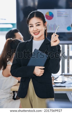 Asian professional successful female businesswoman entrepreneur manager ceo in formal business suit smiling standing posing crossed arms holding pen and touchscreen tablet computer in meeting room. Royalty-Free Stock Photo #2317569927