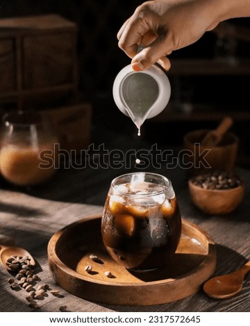 A glass of iced black coffee.  Dripping photography concept 