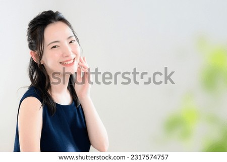 This is a close-up photo of the upper body of a beautiful smiling Japanese woman against a white background. Easy to use for beauty and other advertising images. Copy space available. Royalty-Free Stock Photo #2317574757