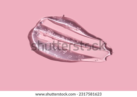 Texture of cosmetic gel on a pink background.
