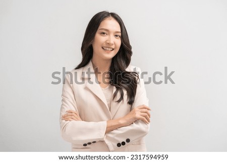 Smiling positive, attractive asian young woman, girl in beige suit formal dress, portrait elegant of pretty with long black hair, feeling happy looking at camera standing isolated on white background. Royalty-Free Stock Photo #2317594959