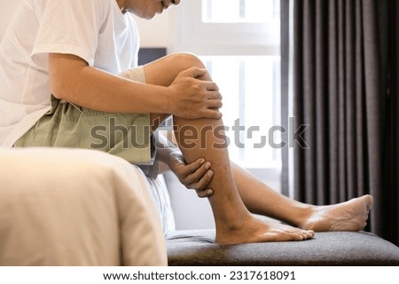 Asian middle aged man have severe cramp his calf of leg,muscle strain,adult male massaging leg with his hands,suffering from muscle cramps,contraction of muscles or tendons,physical injury,health care Royalty-Free Stock Photo #2317618091