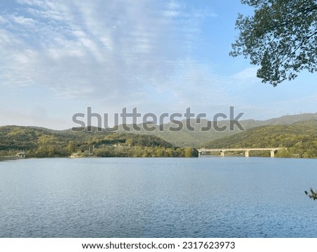 The road crosses the river among the mountains with blue sky