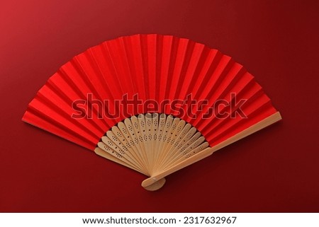 A red hand fan on a red background. Chinese, Japanese, Asian background