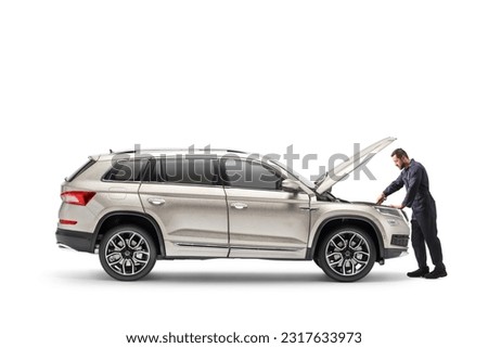 Auto mechanic repairing a SUV with an open hood isolated on white background Royalty-Free Stock Photo #2317633973