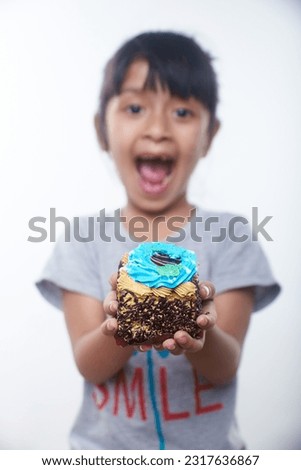 Little toddler girl holding slice of birthday Cake