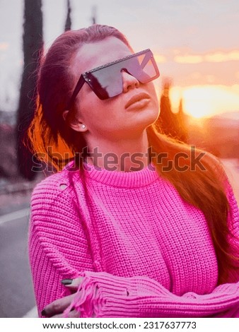 Sunset, Portrait of a girl wearing a pink sweater and sunglasses, capturing her beauty and confidence Royalty-Free Stock Photo #2317637773