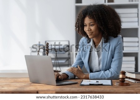 American woman lawyer or businesswoman African working with laptop, searching, analyzing data, reading contract documents work with law books hammer of justice Consulting lawyer concept. Royalty-Free Stock Photo #2317638433