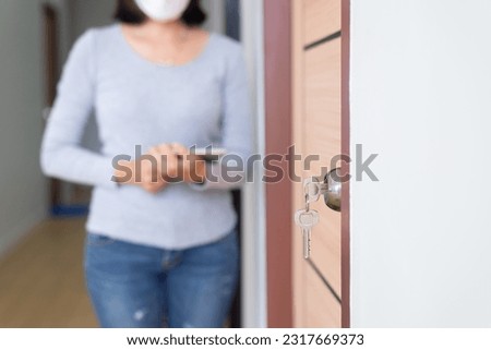Modern doornkop and key with blurred woman inspector at new house,Door knob locks with keys