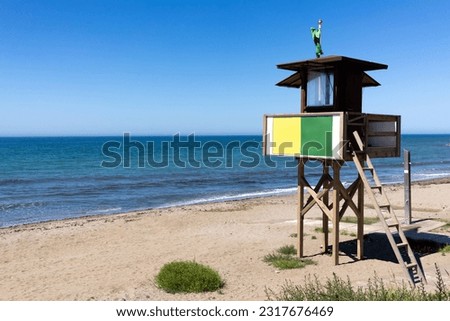 rescue tower on the seashore with a green flag