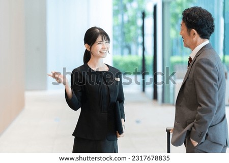 Hotel staff showing guests around Royalty-Free Stock Photo #2317678835