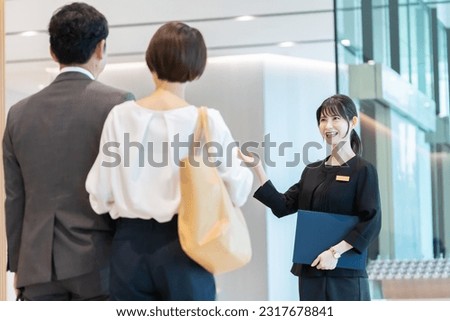 Hotel staff showing guests around Royalty-Free Stock Photo #2317678841