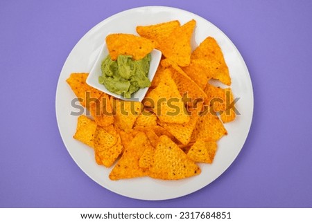 plate of corn chips nachos with guacamole on white plate