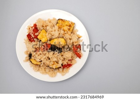 Tasty fresh boiled quinoa with vegetables in white small plate