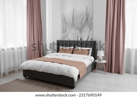 Comfortable bed and lamps in light spacious room. Stylish interior Royalty-Free Stock Photo #2317690149