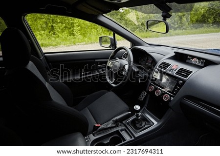 Dark car interior - steering wheel, shift lever and dashboard. Car modern  inside. Side view  Royalty-Free Stock Photo #2317694311