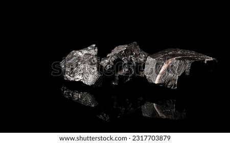 Macro Close up image of raw material Manganese Ore rock isolated on black reflective background Royalty-Free Stock Photo #2317703879