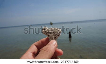 heart shaped stone in hand on the background of the sea. ecotourism and Concept harmony between recreation and ecology. love to travel and relax in nature on kartini beach 