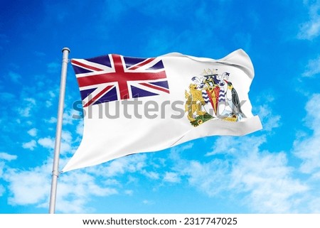 British Antarctic Territory flag waving in the wind, blue sky background