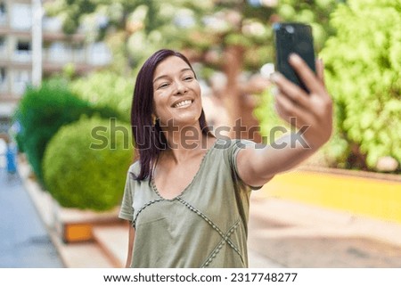 Young beautiful hispanic woman smiling confident making selfie by the smartphone at park