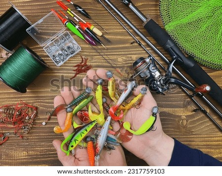 Fishing tackle. Float, wobbler, bait hooks, on a wooden background. Selective focus Royalty-Free Stock Photo #2317759103
