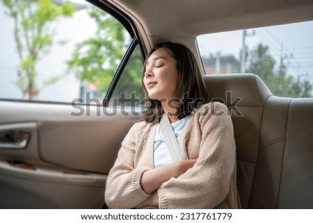 Relaxing moment of beautiful woman sleeping in car back seats with safety belt. Female happy in car while traveling on the road to your destination. Royalty-Free Stock Photo #2317761779