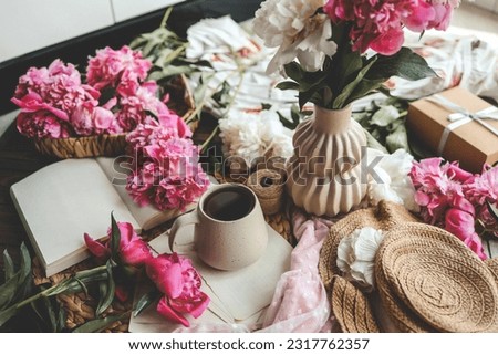 Beautiful spring composition, good morning concept. Cup of tea, peonies and open book.