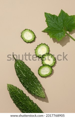 Natural fruit concept with bitter melon cut in slices over a light background. Bitter melon (Momordica charantia) is beneficial for our eyes’ health and improve vision Royalty-Free Stock Photo #2317768905