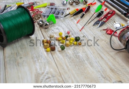 lot of colorful lures with the fishing rod on the wooden pier Royalty-Free Stock Photo #2317770673