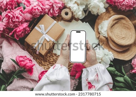 Mobile phone and spring flower peonies on a festive background. Theme of love, mother's day, women's day flat lay.