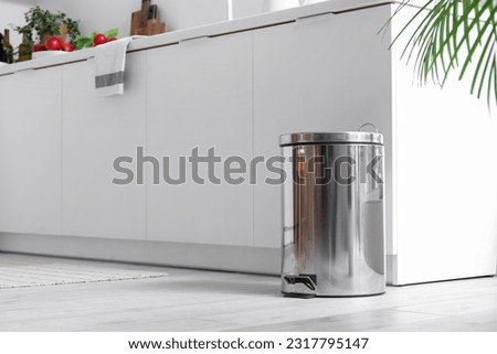 Metallic trash bin in interior of modern kitchen Royalty-Free Stock Photo #2317795147