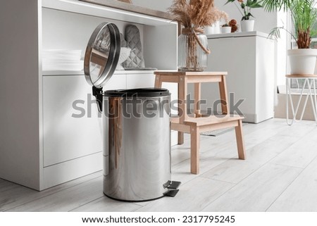Opened metallic trash bin in interior of modern kitchen Royalty-Free Stock Photo #2317795245