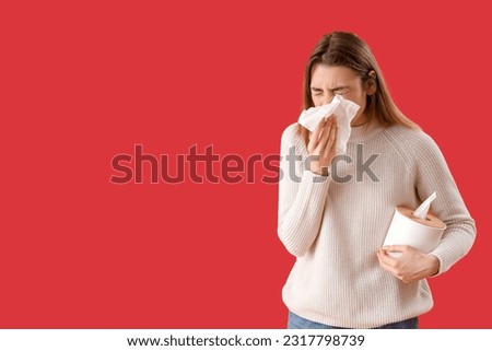 Ill young woman with tissues on red background