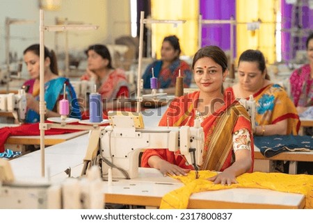 Indian women group working on sewing machine at textile factory. Royalty-Free Stock Photo #2317800837