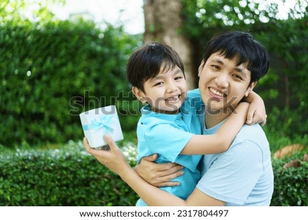 Lovely Asian little young boy giving his daddy the greeting card for the international father's day, lovely boy gives his father a drawing DIY Father's Day greeting card. Royalty-Free Stock Photo #2317804497
