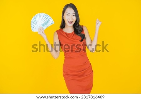 Portrait beautiful young asian woman smile with a lot of cash and money on color background