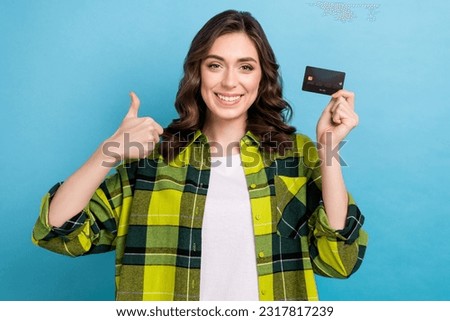Photo of funky confident lady wear checkered jacket showing thumb up holding credit card isolated blue color background