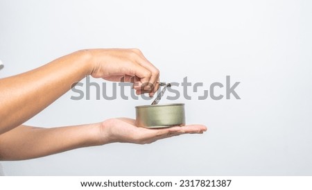 Hand holds canned food isolated on white, woman hands. Royalty-Free Stock Photo #2317821387