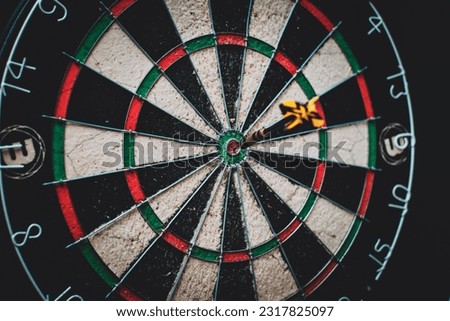 Dartboard with dart arrow in the center of the target.