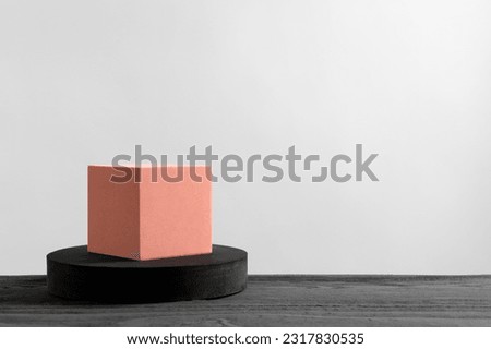 Cube and round shaped podiums on grey wooden table. Space for text