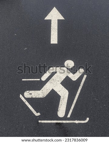 direction sign on the sidewalk.  sign on the road.  movement indicator.  roller ski movement.