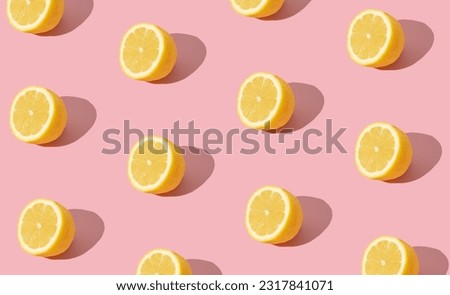 Trendy sunlight summer fruit pattern made with yellow lemon slice on bright light pink background. Minimal summer concept. Creative food idea. Lemons aesthetic.
