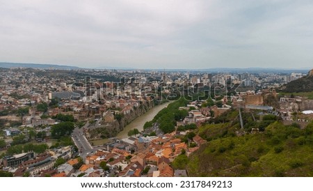 The city of Tbilisi and the Kura river from a bird's eye view. Panoramic review of the city of Tbilisi from a height. Aero photo with drone. Traveling in Georgia, background with Tbilisi.